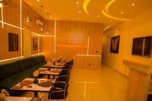 拉各斯Elcastillo Homes的餐厅设有长桌和绿沙发