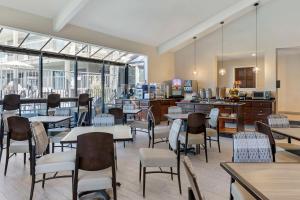 罗兰岗最佳西方加商务酒店的用餐室设有桌椅和窗户。