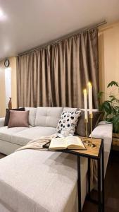 纳尔瓦Top Located Narva Apartment的客厅配有沙发和一张桌子及一本书