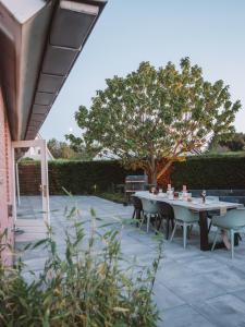泽沃德Luxurious Family Villa with swimmingpool big garden and jacuzzi的一个带桌椅和树的庭院