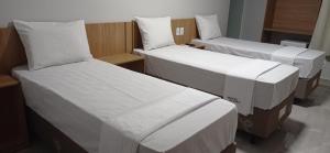 圣保罗Hotel Bonina的一间设有两张带白色床单的床的房间