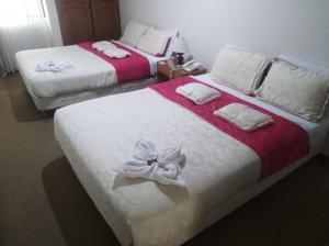波哥大卡萨拉里维埃拉酒店的客房内的两张床,上面有白色的鲜花