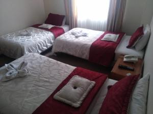 波哥大卡萨拉里维埃拉酒店的酒店客房设有三张床和窗户。