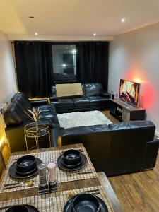 伯明翰Luxury 1 or 2 bedroom Apartment Birmingham City Centre的客厅配有黑色真皮沙发和桌子