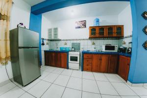 廷戈玛丽亚Tulumayo House的厨房配有木制橱柜和不锈钢冰箱。