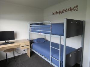 芒奥努伊Hihi Getaway的一间卧室配有两张双层床和一张书桌