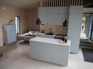 罗瓦涅米Scandinavian lakeside cottage的厨房配有白色橱柜、水槽和床。