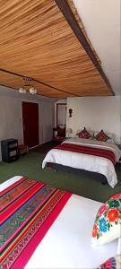 普诺Uros Waliski Lodge的一间卧室设有两张床和木制天花板