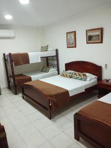 巴兰基亚hotel paseo colon inn的一间卧室配有两张床和一张双层床。