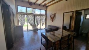 GranizoCabaña en Olmue con piscina compartida的客厅设有桌子和大窗户