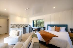 欧尼坦基Onetangi Beach Stays Studio 2 - Coast & Country的一间带大床的卧室和一间厨房