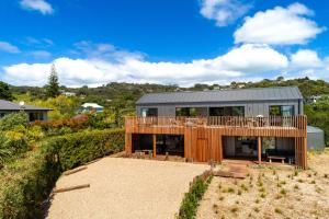 欧尼坦基Onetangi Beach Stays Studio 2 - Coast & Country的庭院顶部有甲板的房子