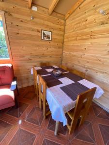 富特罗诺CABAÑAS RUCA MALAL的小屋内带桌椅的用餐室