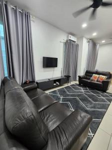 关丹MIHI Homestay Pantai Sepat的客厅配有真皮沙发和平面电视