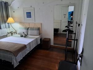 里约热内卢Sobrado Botafogo的一间卧室配有一张床,另一间卧室配有镜子