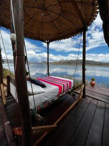 普诺Uros Waliski Lodge的水景门廊上的一张床位