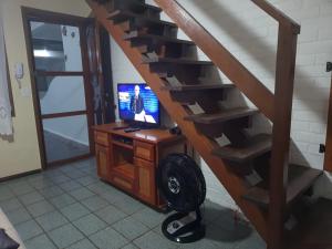 卡波布里奥CASA PERO CABO FRIO a 60 Metros da praia的客房设有带电视和书桌的楼梯。