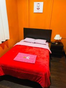 利马KORICANCHA的一间卧室配有红色的床和红色毯子