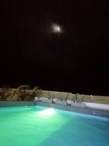 卡诺阿斯德蓬萨尔Casa de Playa Las Fragatas de Punta Mero的夜晚的游泳池,天空中月亮