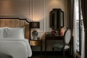 河内GM Premium Hotel的一间卧室配有一张床、一把椅子和镜子
