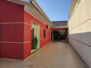 伊瓜苏Quarto aconchegante na terra das cataratas的一座有红色墙壁的建筑的空走廊