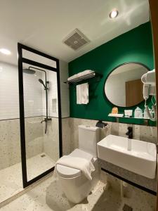 丹戎槟榔Alltrue Hotel Bintan - Tanjungpinang的一间带卫生间、水槽和镜子的浴室