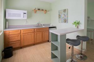 塔穆宁Ocean Villa Guam的厨房配有水槽和带两个凳子的台面