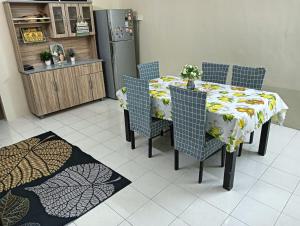 斯里伊斯兰德Homestay Itqan Seri Iskandar的用餐室配有桌椅和冰箱