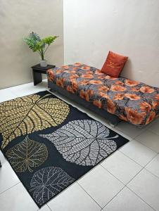 斯里伊斯兰德Homestay Itqan Seri Iskandar的一张沙发,坐在一个有两块地毯的房间
