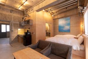 别府HAJIMARI Beppu的一间卧室配有一张大床和一张沙发