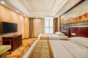 宝安Vienna Hotel Shenzhen International Airport的酒店客房设有两张床和一台平面电视。