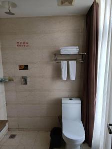 哈尔滨哈尔滨华西宾馆(冰雪大世界店)的一间带卫生间和毛巾架的浴室