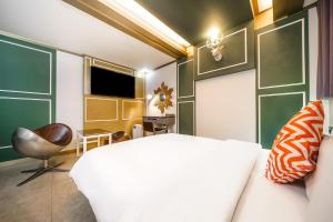GongjuGongju No 25 Hotel的卧室配有白色的床和椅子