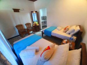 卡图纳耶克Dinu Lanka Resort的一间带两张床的卧室和一间客厅