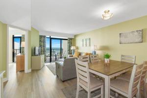 默特尔比奇Breathtaking Oceanfront 3BR,2BA Suite/Grand Cayman 451的用餐室以及带桌子和沙发的客厅。
