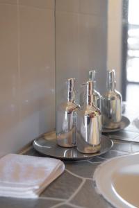 拜县Betel Palm Village - Casa Retreat的浴室柜台的托盘上放有4瓶
