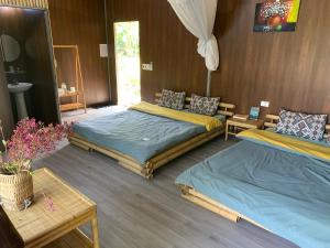 高平Luong Son Homestay Ecolodge的一间卧室配有两张床、一张桌子和一面镜子