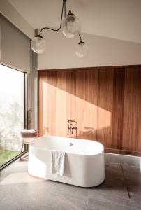 Hsin-ying未艾公寓WeLove Apartment的浴室设有白色浴缸,拥有木墙