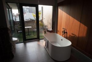 Hsin-ying未艾公寓WeLove Apartment的带浴缸的浴室和大窗户