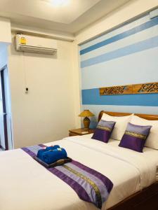 清迈维瑞雅别墅酒店的一间卧室配有两张带紫色枕头的床