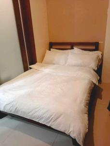 马尼拉Casa De Familia Staycation的白色的床、白色床单和枕头