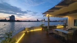 曼谷Riverfront house/Chao phraya river/Baan Rimphraya的甲板享有夜间水景