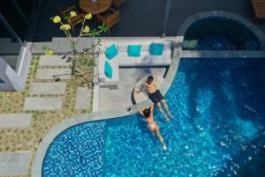 塞隆贝拉纳克Tropik Resort Lombok的一个人在游泳池里