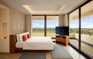 菩提伽耶Hyatt Place Bodh Gaya的一间卧室配有一张床和一台平面电视