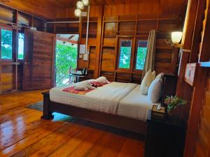 俊穆岛Kohjum Seafront Resort的卧室配有一张床铺,位于带木墙的房间内