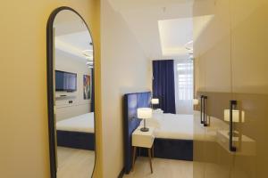 伊斯坦布尔Ravello Suites Taksim的一间镜子位于酒店客房,设有一间卧室