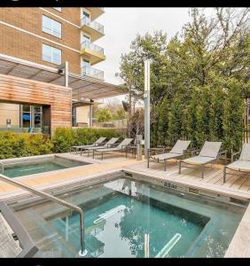 达拉斯Luxurious & cozy 2bedroom/2bath apt downtwn Dallas的一座带两把椅子的游泳池以及一座建筑