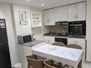 加利布港fully finished, very cozy and comfortable studio的厨房配有白色橱柜和大理石台面