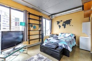 埃德蒙顿Industrial-Style Cityscape 1 Bedroom Loft的一间卧室配有一张床和一台电视。