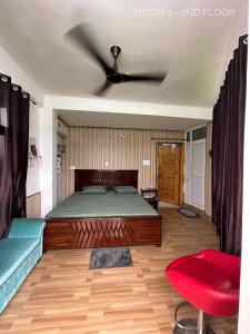 达兰萨拉Dhauladhar Homes的一间卧室配有一张床和吊扇